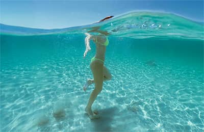 Woman standing in the ocean while snorkeling